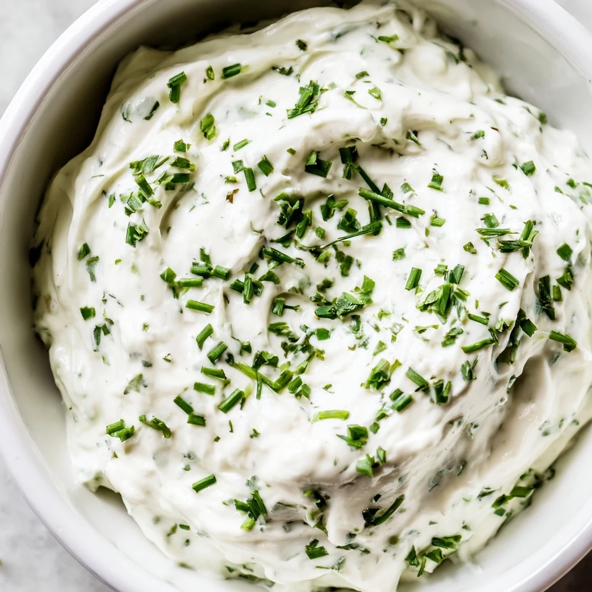 A close-up of Creamy Snack Dip surrounded by crunchy pita chips and colorful fresh vegetables.