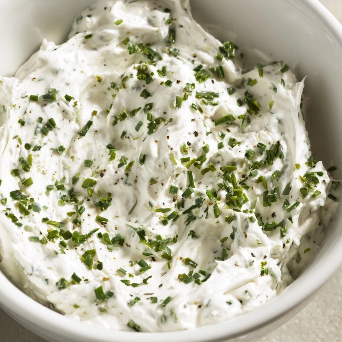 White bowl of creamy Creamy Snack Dip on a napkin, ready for a party snack spread.
