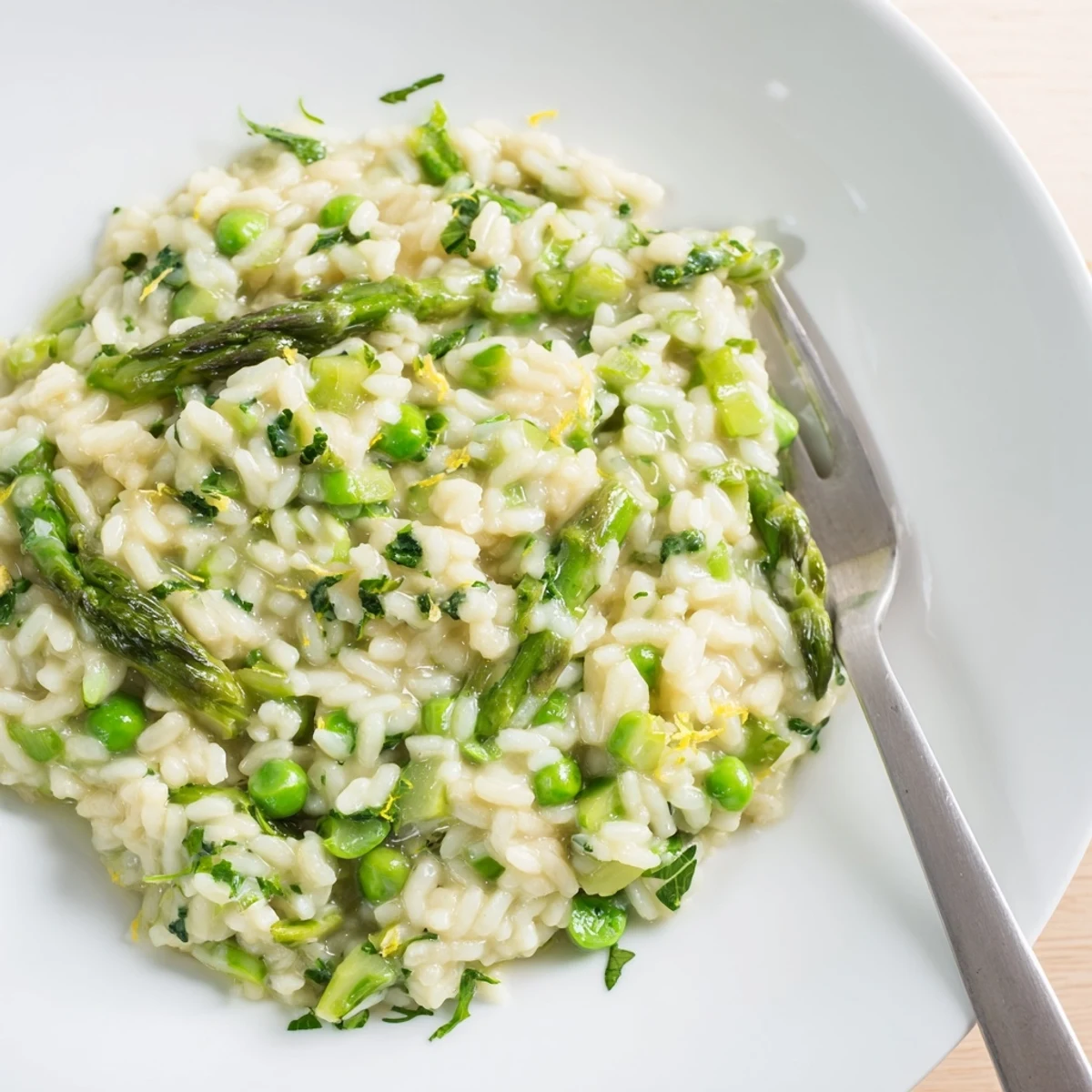 Close-up of Spring Pea and Asparagus Risotto, highlighting vibrant green peas and asparagus spears mixed into a rich, cheesy Italian main dish.  