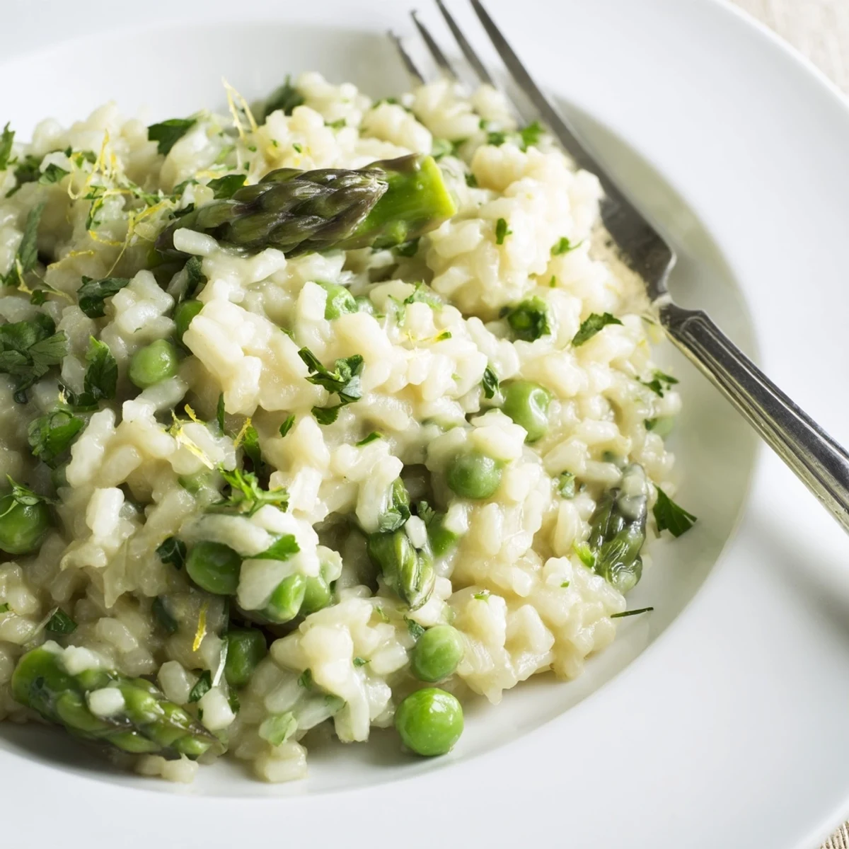 Steaming Spring Pea and Asparagus Risotto served as a luxurious vegetarian side, featuring bright spring vegetables and a creamy Parmesan finish.