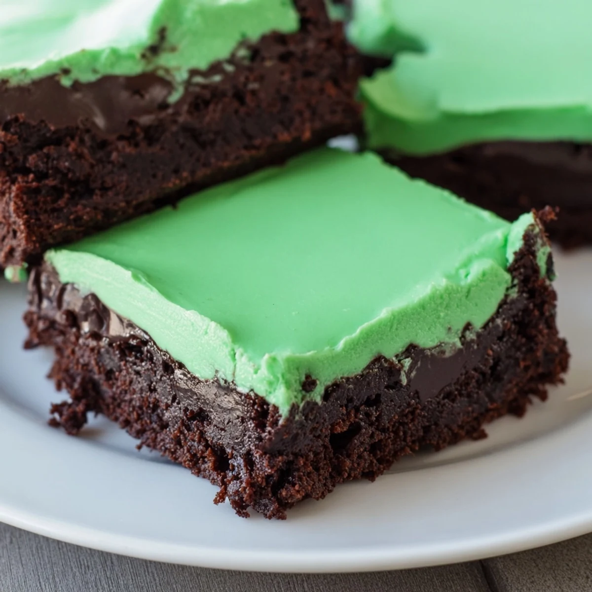 A close-up slice reveals the vibrant mint frosting inside these Green Mint Brownies.