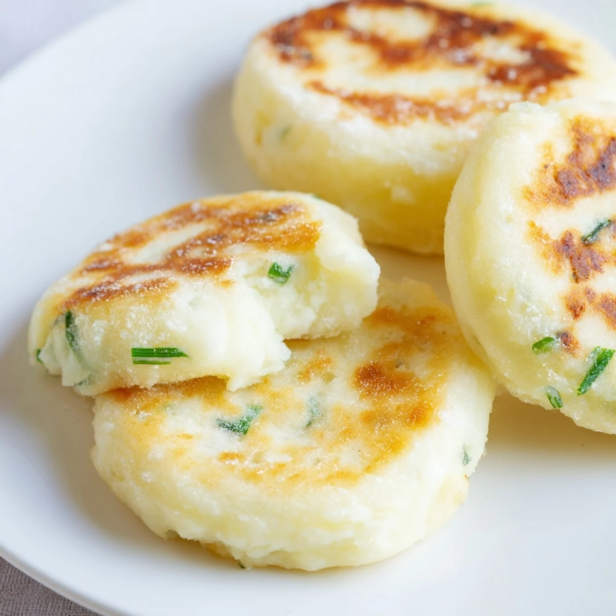 Golden, pan-fried Irish Potato Cakes with Scallions are crisp on the outside and fluffy inside, served warm with butter.  