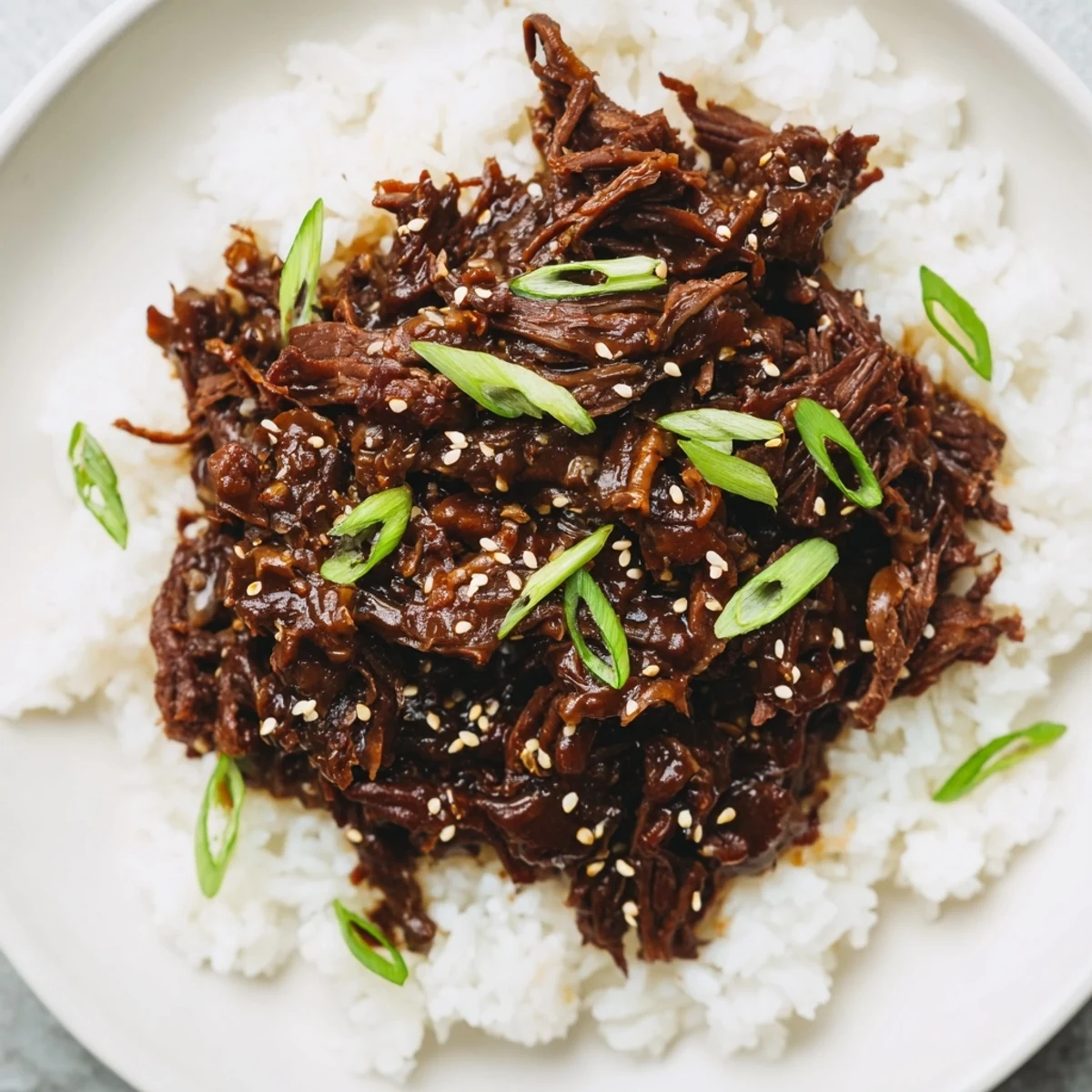 Slow cooker Korean beef served in crisp lettuce wraps with spicy gochujang sauce and sliced red chili.