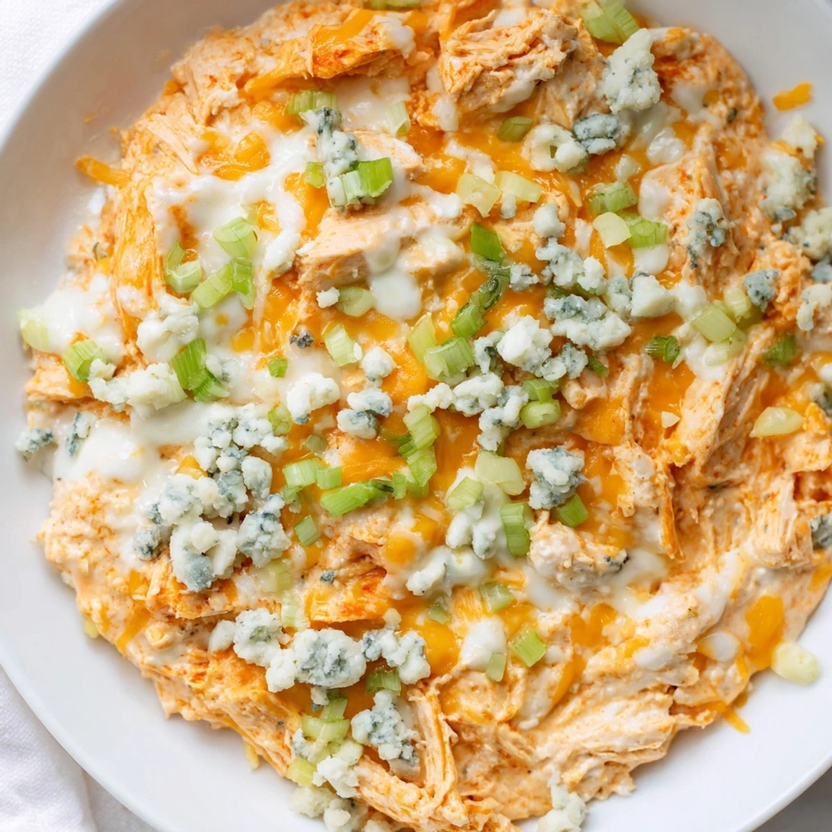 Creamy Keto Buffalo Chicken Dip with melted cheese and shredded chicken, served warm with celery sticks for dipping.  