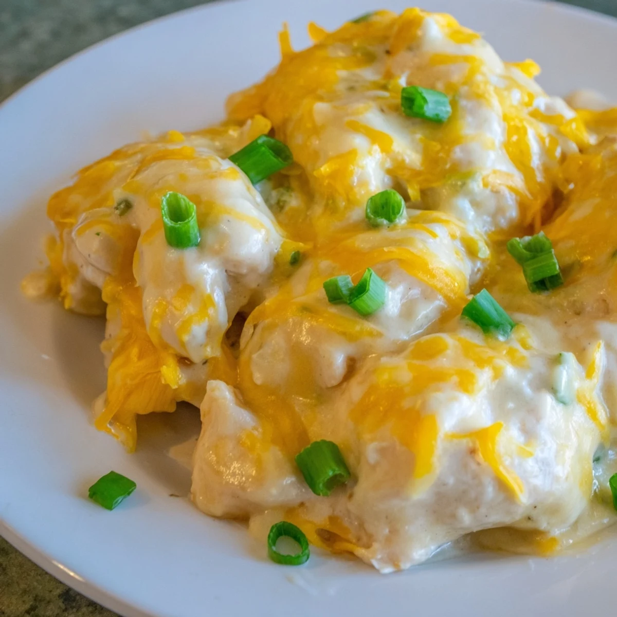 A close-up of Sour Cream and Onion Chicken fresh from the oven, with bubbly sauce and a crunchy golden topping. Served hot for a family meal.