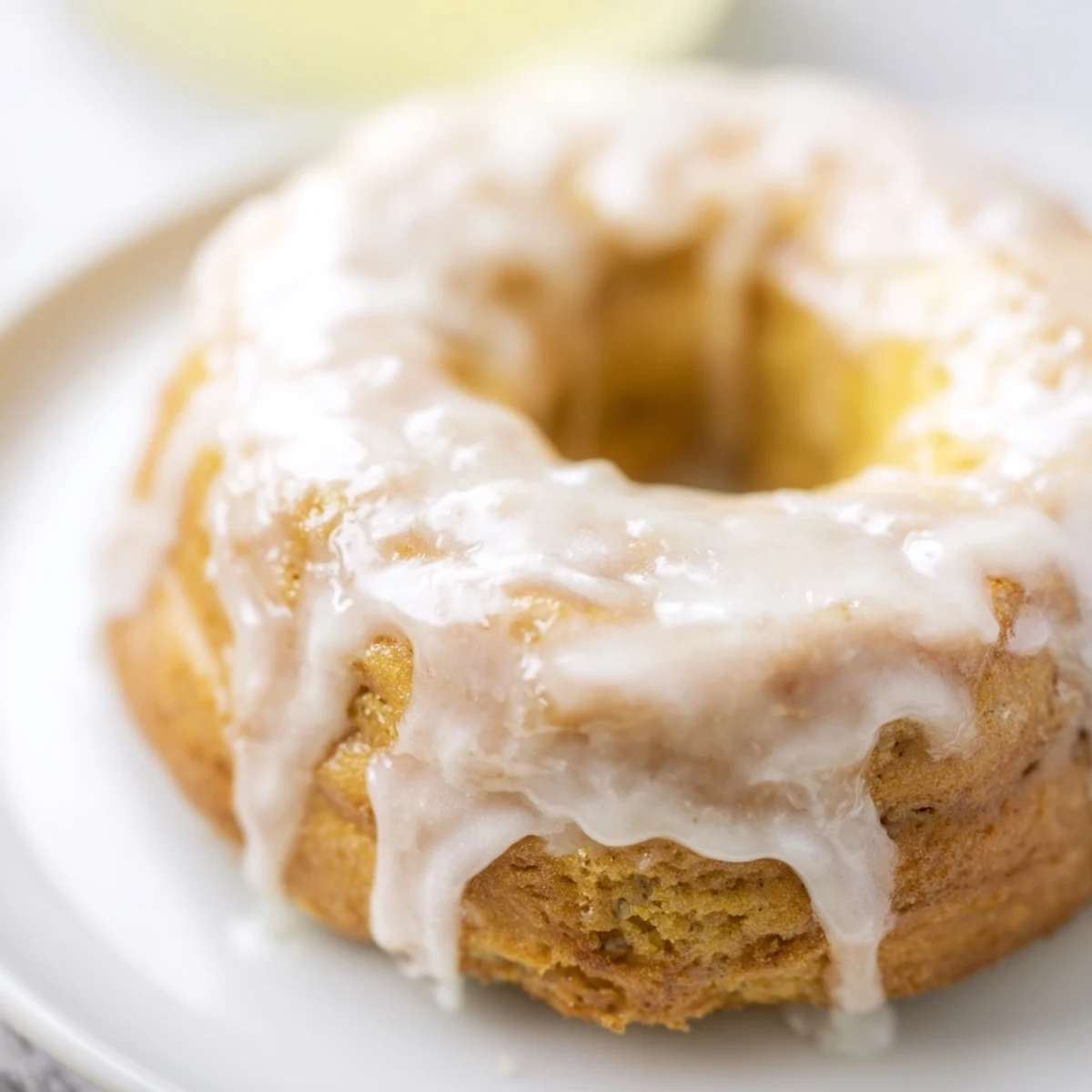 Warm Baked Banana Bread Donuts dusted with cinnamon sugar on a wire rack for cooling.