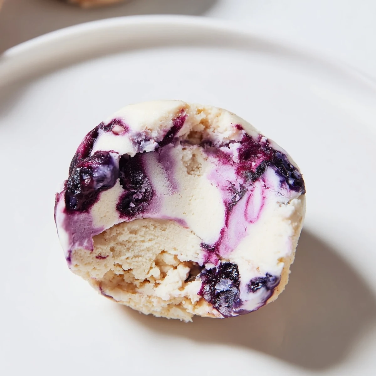 Homemade Blueberry Cheesecake Protein Bites arranged on a rustic wooden serving board.