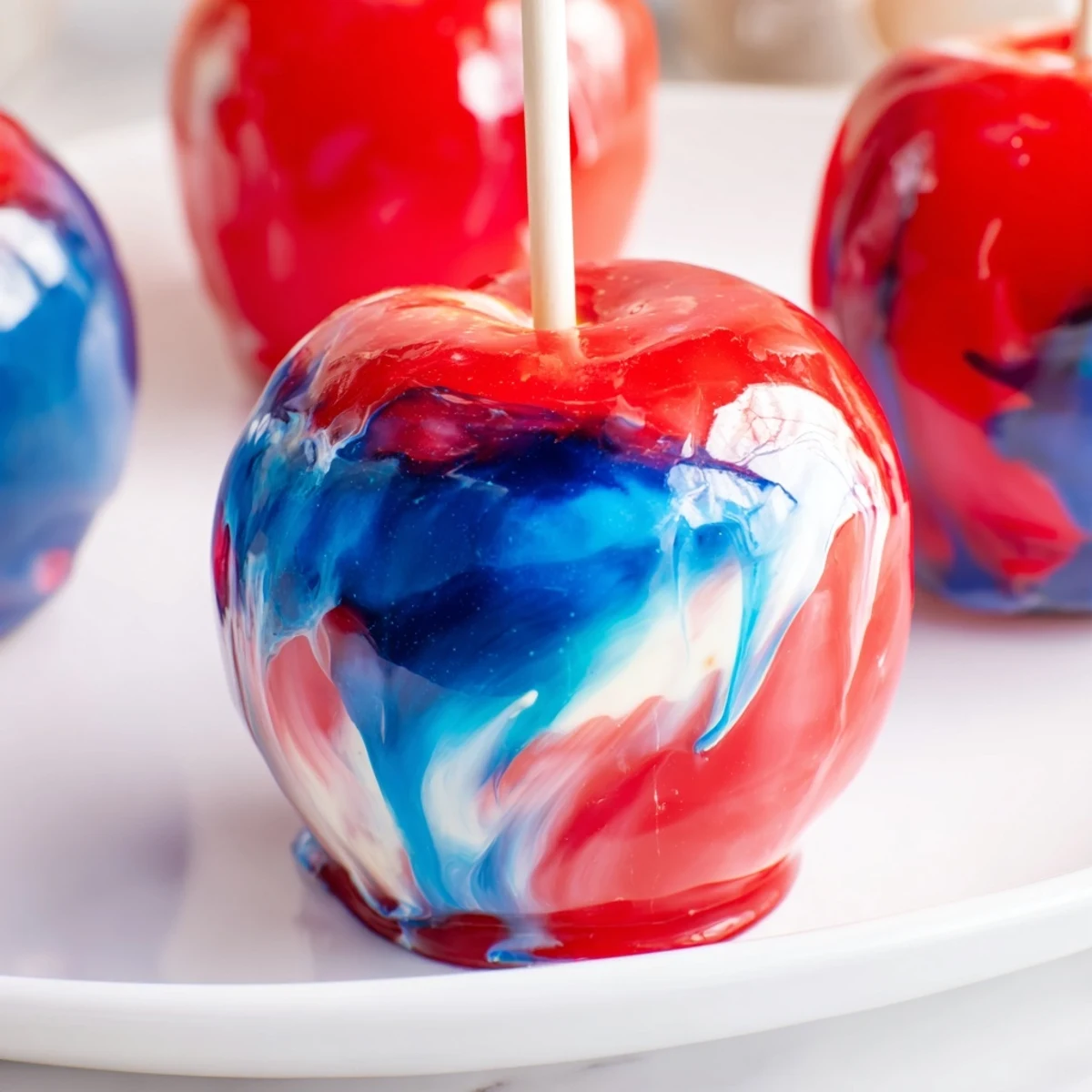 Freshly dipped Marbled Effect Candy Apples with a shiny, swirled red and blue candy coating on crisp apples.