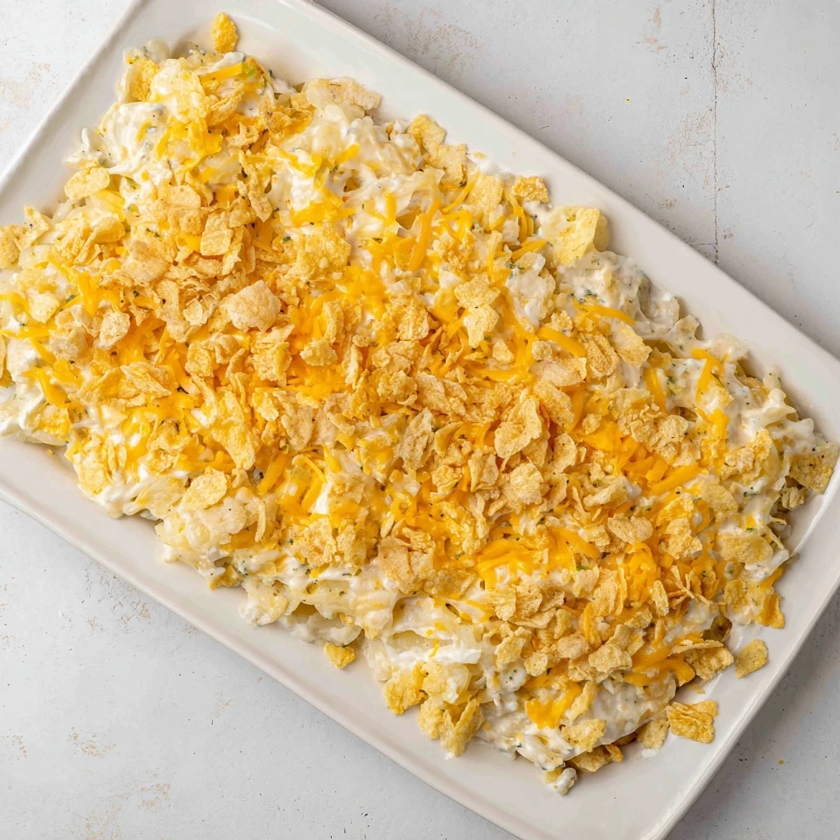 A close-up of cheesy Funeral Potatoes with Hashbrowns, featuring a creamy, bubbling casserole with tender shredded potatoes and melted cheddar.