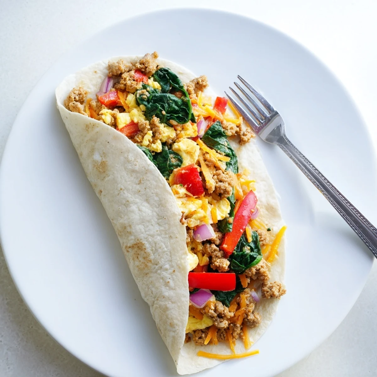 Warm flour tortillas wrapped around eggs, bell peppers, onions, and cheese in these hearty breakfast burritos