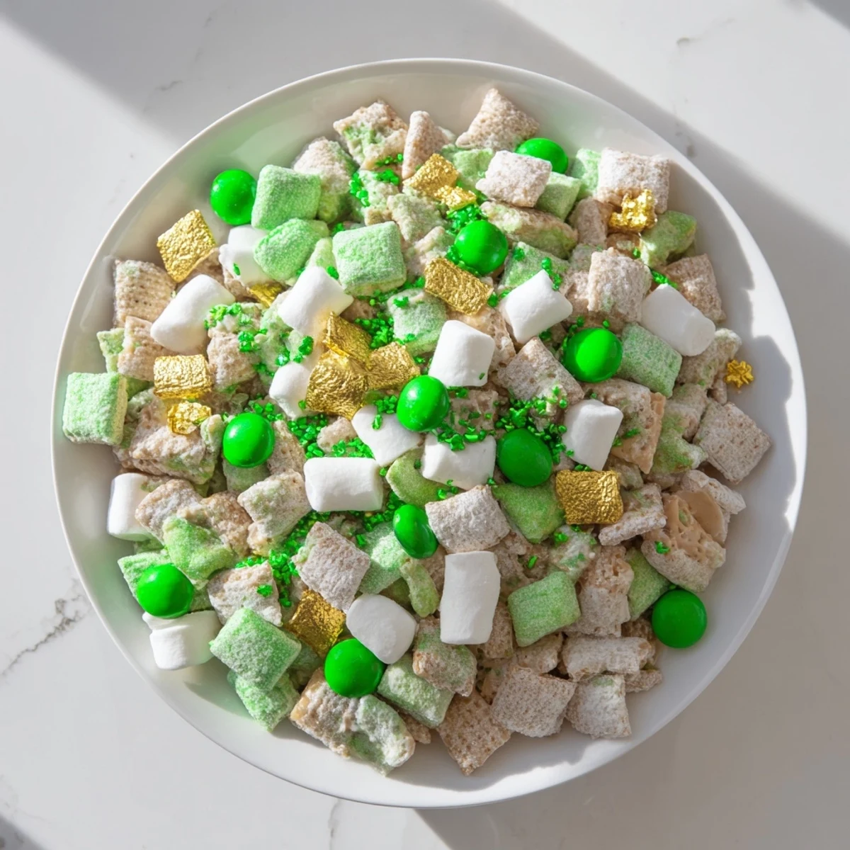 Colorful St. Patricks Day Lucky Chow tossed with green candies, marshmallows, and gold chocolate coins