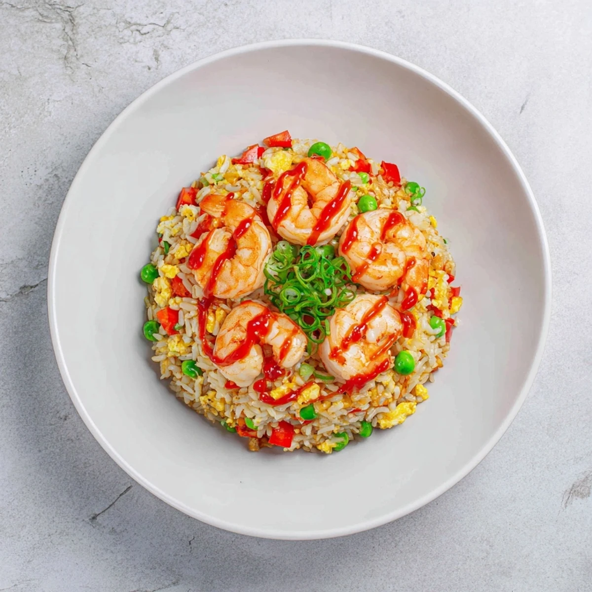 Plate of juicy garlic butter prawns served over spicy sweet chilli vegetable fried rice