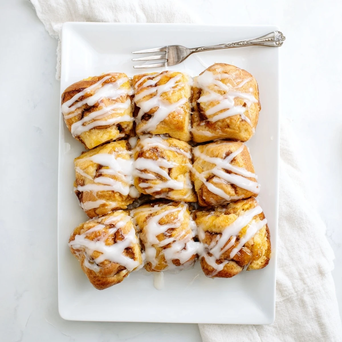 Fluffy biscuits swimming in peach infused butter topped with creamy vanilla glaze
