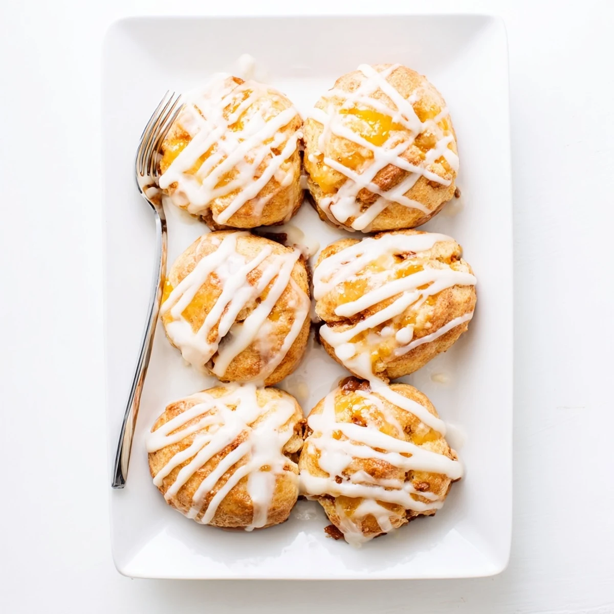 Warm peach butter swim biscuits fresh from the oven with vanilla glaze coating