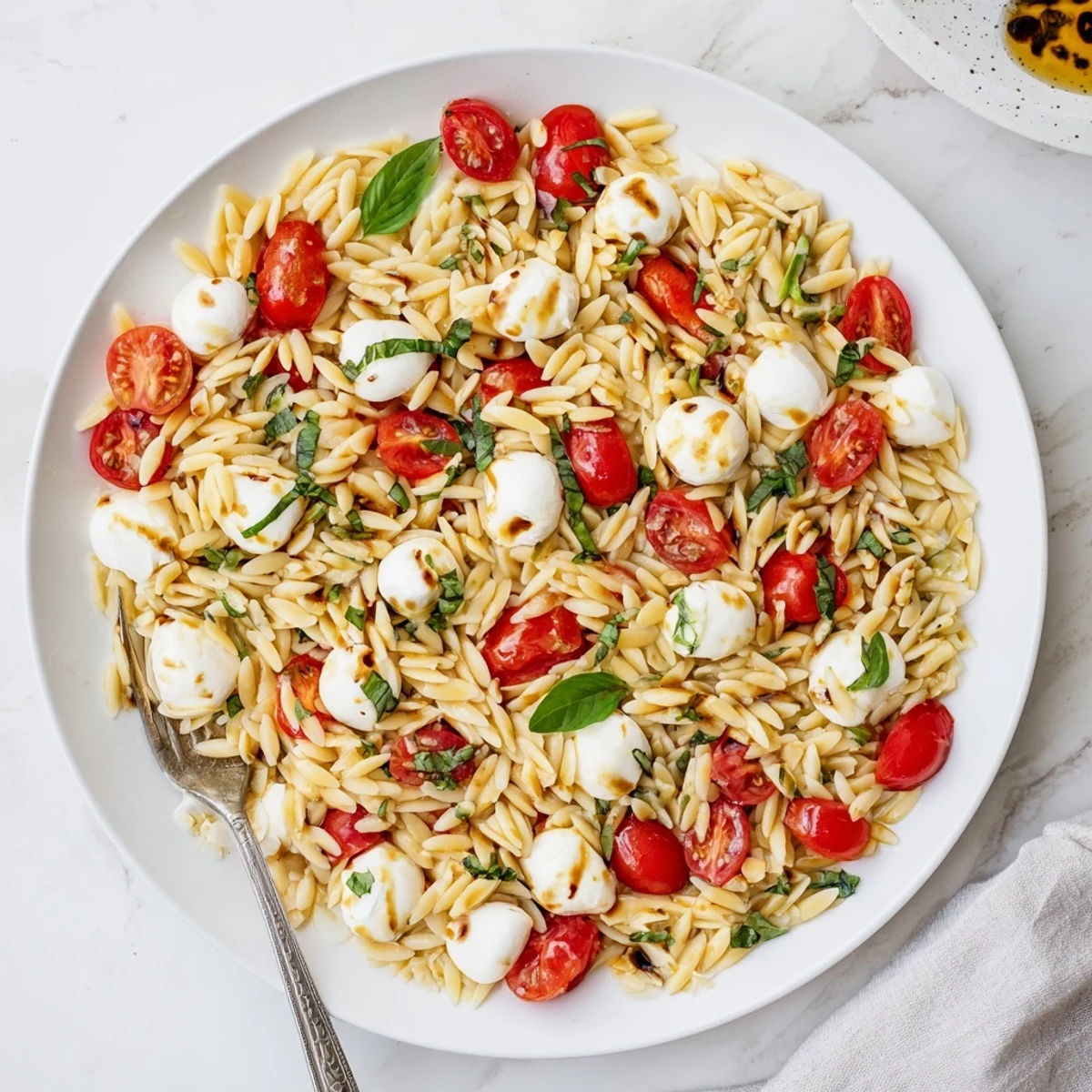 Fresh Caprese Orzo Pasta Salad tossed with basil and drizzled with balsamic vinaigrette