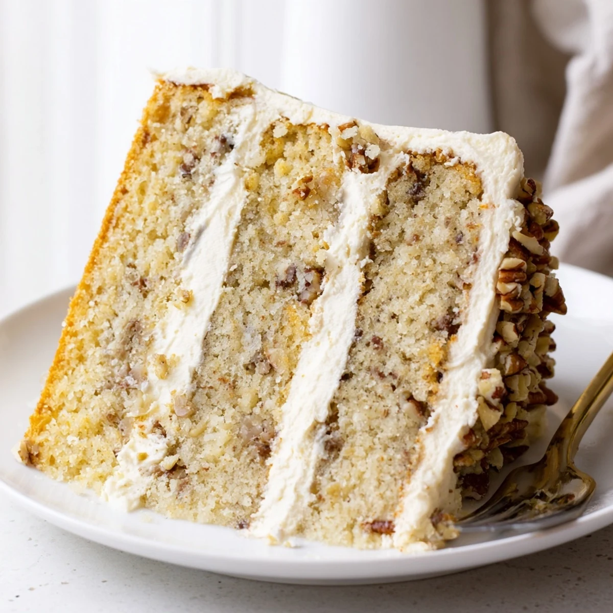 Moist butter pecan cake close-up showing chopped pecans embedded in buttercream frosting