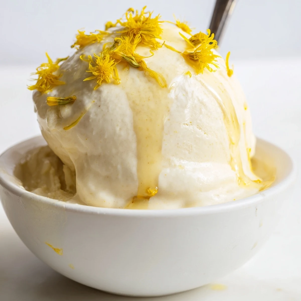 Velvety floral dandelion honey ice cream served with fresh dandelion petals on top