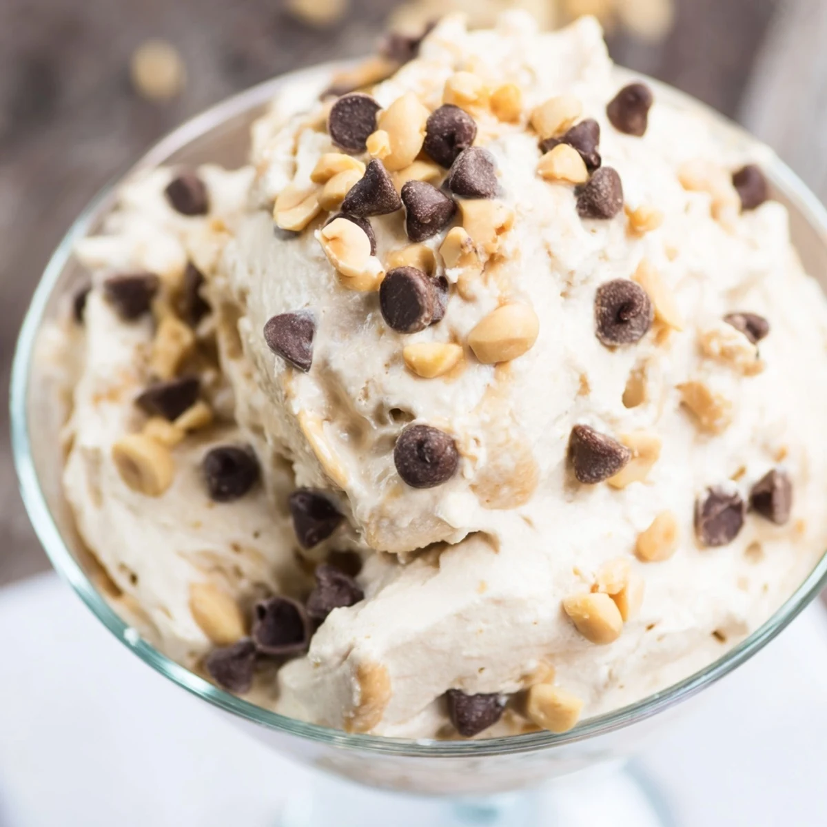 Creamy peanut butter and Cool Whip mousse topped with crushed roasted peanuts in a glass serving dish