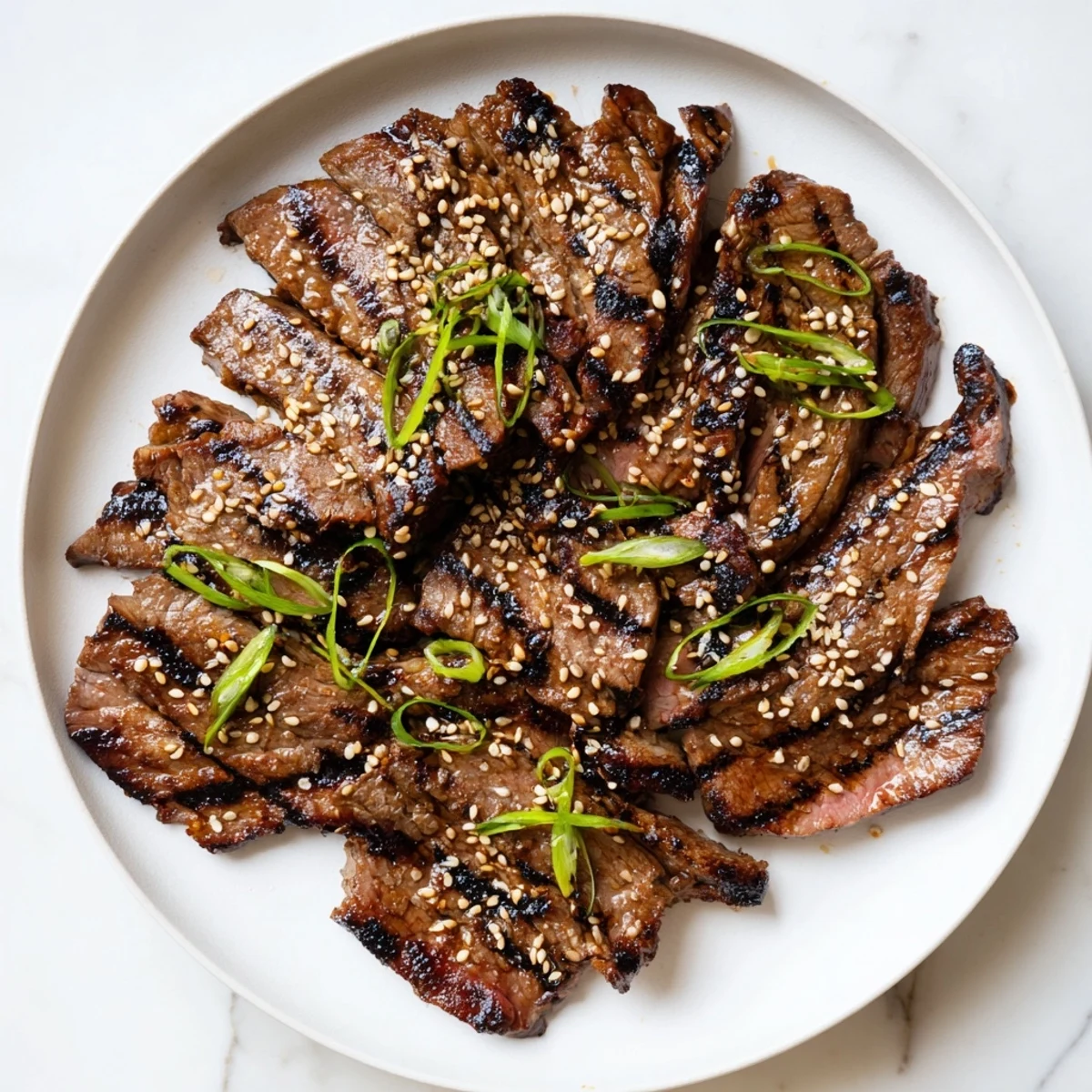 Sizzling beef yakiniku with caramelized edges served alongside charred vegetables and steamed white rice