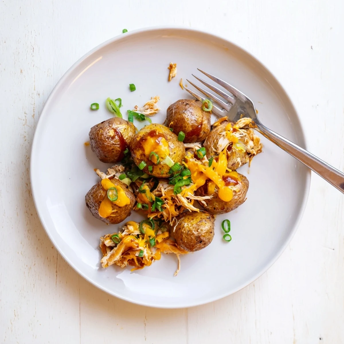 Bubbling honey BBQ chicken potatoes fresh from the oven with shredded cheddar on top