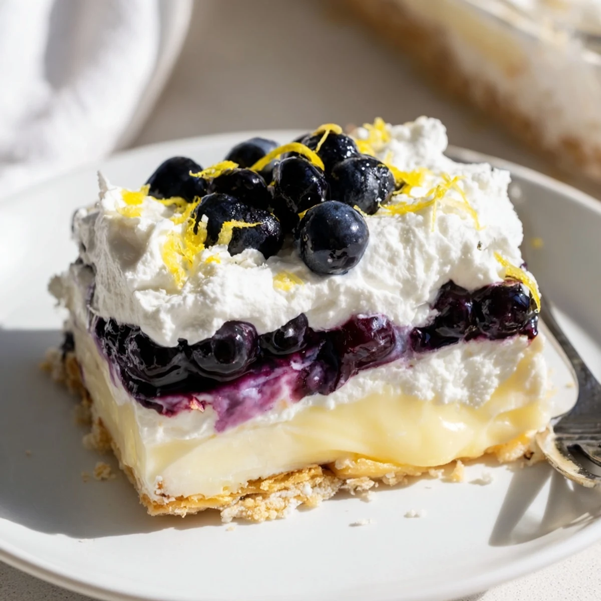 Bright Lemon Blueberry Lasagna Recipe topped with whipped cream and fresh blueberries
