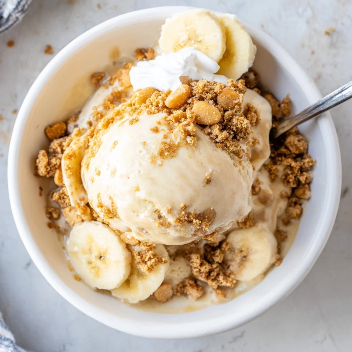 Scoop of Ninja Creami Banana Cream Pie Ice Cream on vintage bowl, sliced bananas