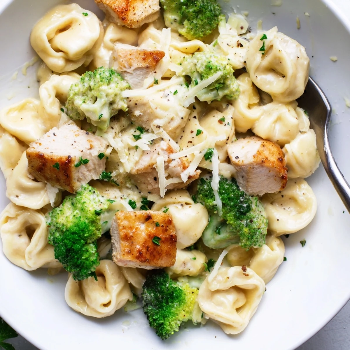 Creamy Garlic Parmesan Tortellini Chicken Broccoli Recipe steaming in skillet, Parmesan melting
