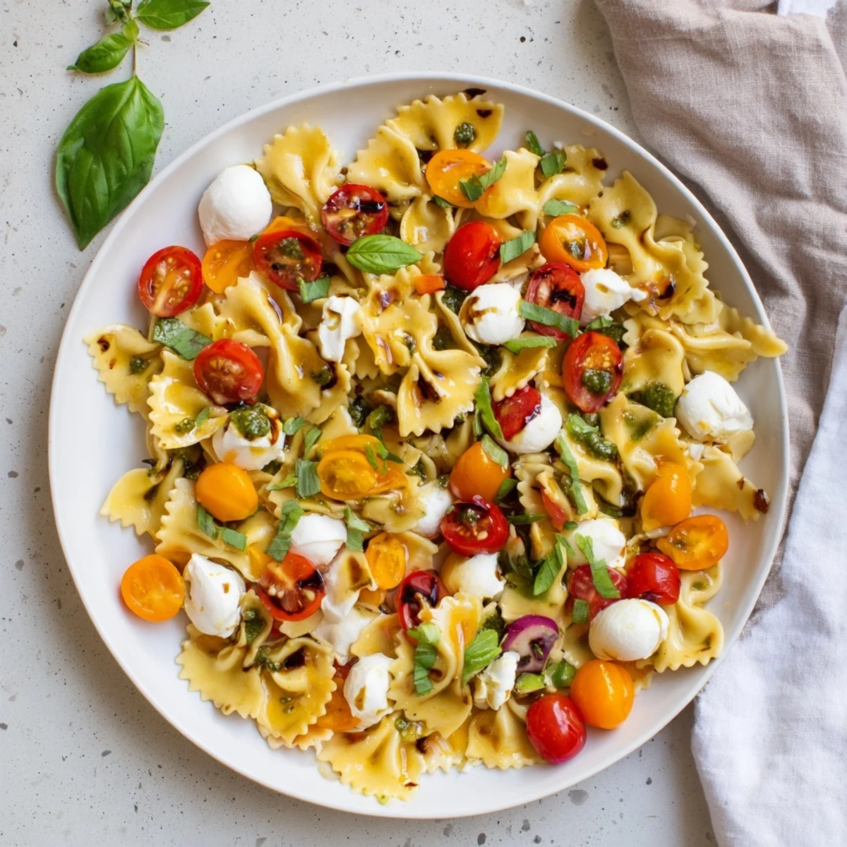 Colorful Caprese Pasta Salad with juicy cherry tomatoes and torn basil