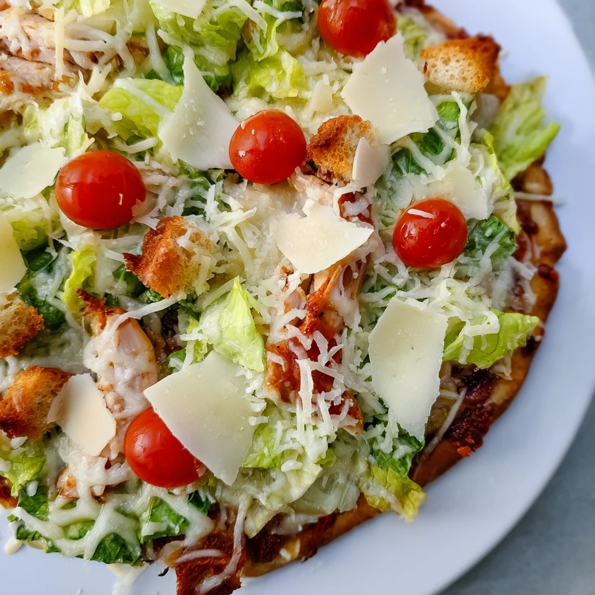 Crispy crust pizza loaded with seasoned chicken and creamy Caesar dressed lettuce