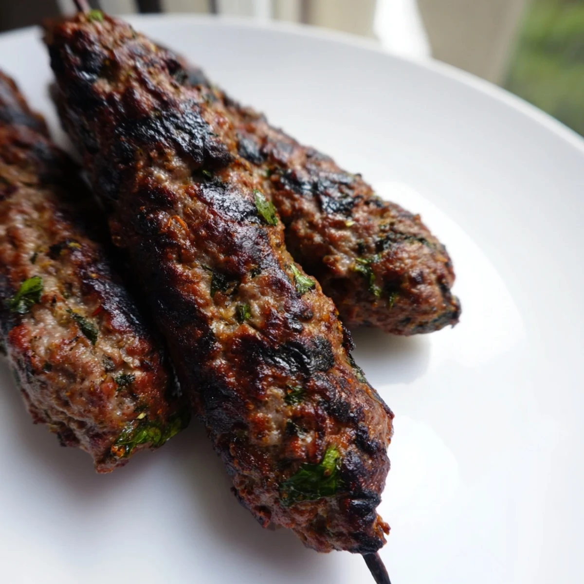 Juicy Middle Eastern Lamb Kofta Kebabs served with lemon wedges on a platter