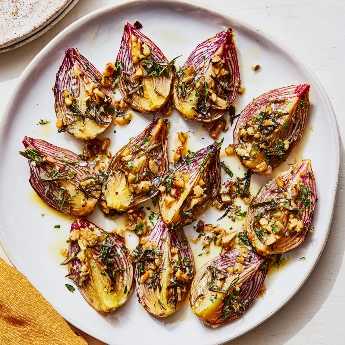 Golden brown savory garlic herb roasted radishes arranged on a white serving plate