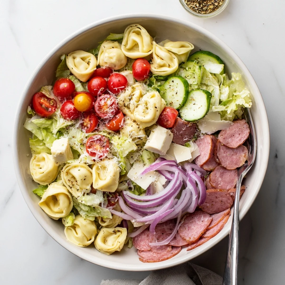 Hearty pasta salad featuring cheesy tortellini tossed with crisp vegetables and zesty dressing