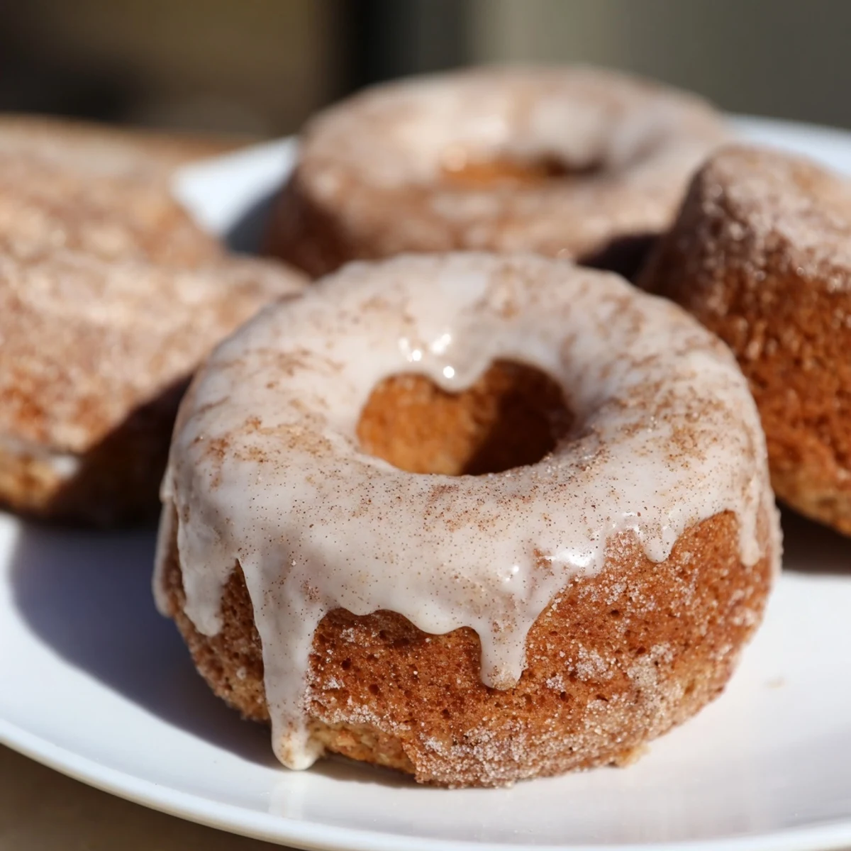 Golden banana bread donuts topped with sweet cinnamon glaze on a wire cooling rack