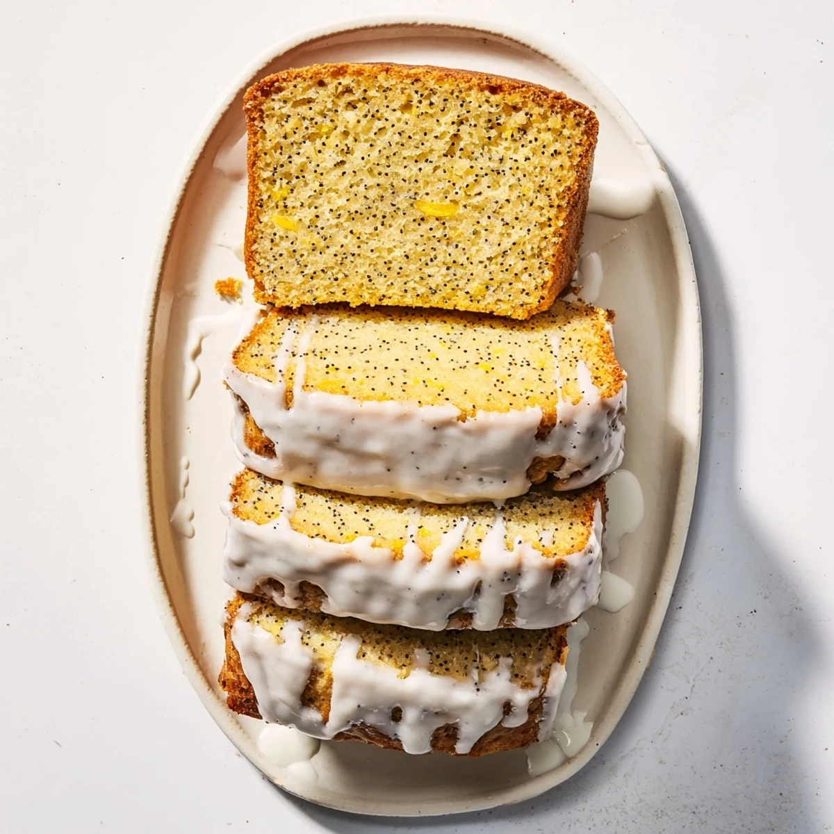 Moist lemon poppy seed loaf cake topped with sweet lemony glaze and poppy seed speckles