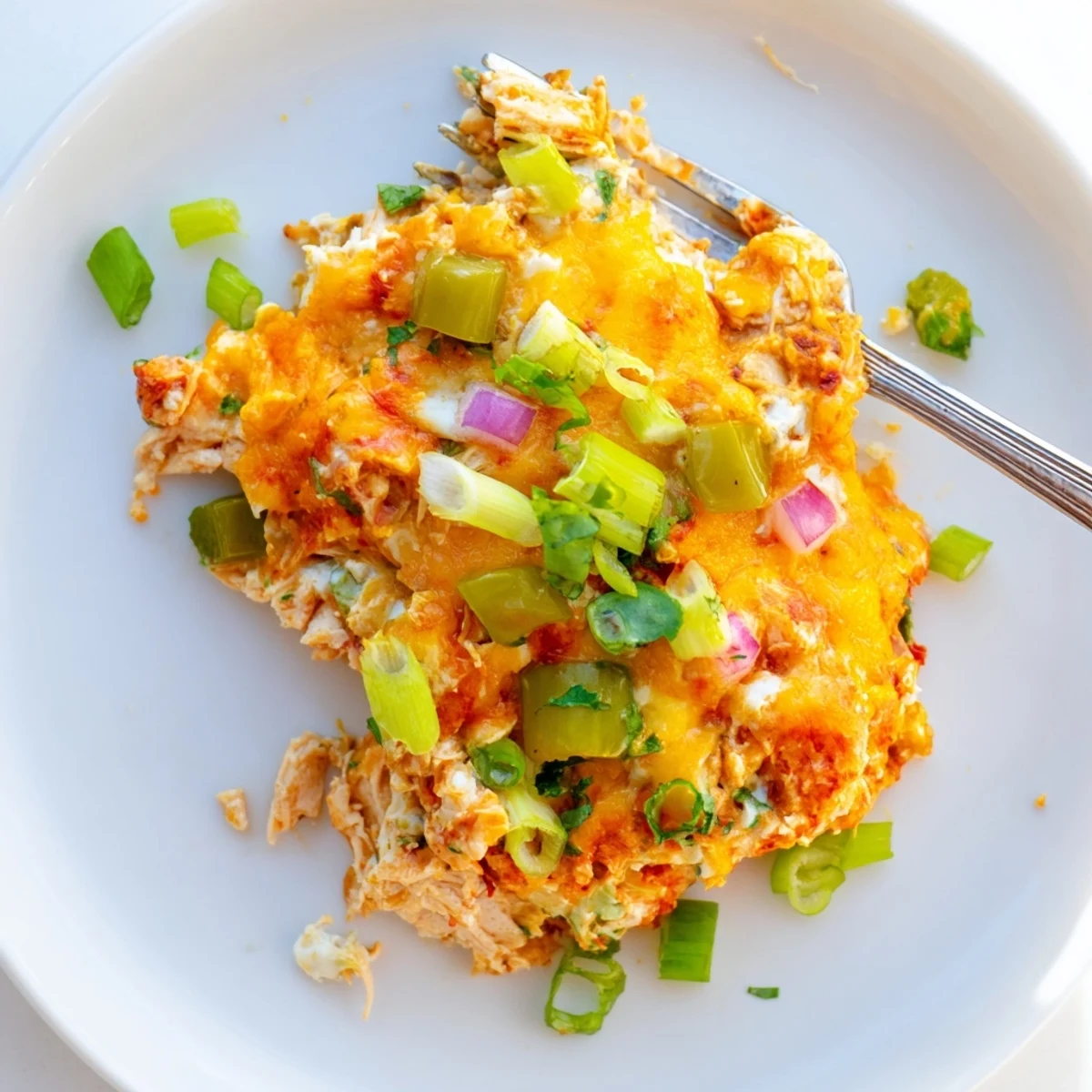Golden bubbling jalapeno buffalo chicken casserole fresh from the oven, topped with melted cheddar and mozzarella