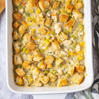 Comforting Dolly's Chicken Stuffing Casserole paired with a crisp green salad on a rustic wooden table.